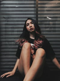 Beautiful young woman sitting on floor