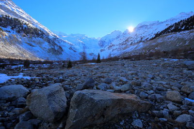 Scenic view of snow covered mountains against blue sky