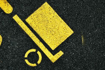 Close-up of yellow arrow symbol on road