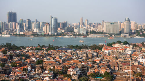 Cityscape by sea against clear sky