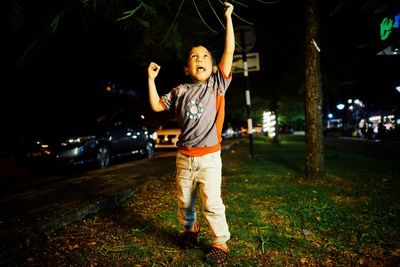 Full length of man standing in illuminated park at night