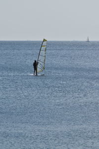 Man surfing in sea against sky