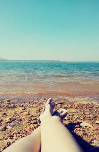 Low section of woman standing on beach