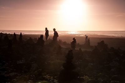 Stack of stones on beach at sunset