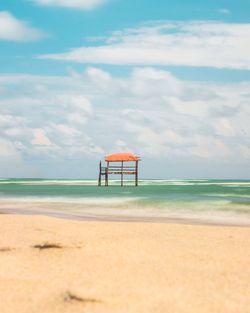 Lifeguard hut on beach against sky