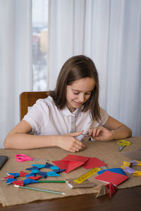 A beautiful teenage girl makes origami