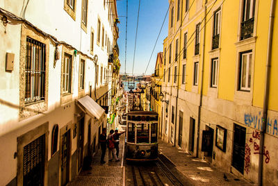 Tramway amidst buildings on street against sky in city