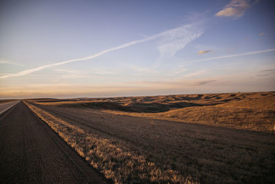 Scenic view of agricultural field against sky during sunset