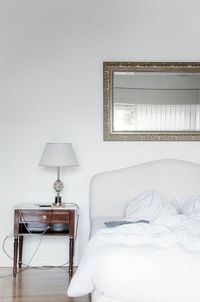 Table lamp by cropped bed in the bedroom