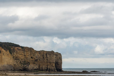 Rock formations by sea against sky