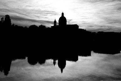 Silhouette built structure in calm lake