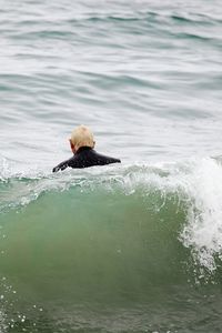 Rear view of man swimming in sea