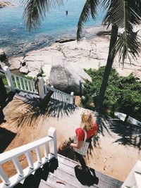 Woman standing on staircase at beach