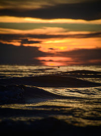Surface level of sea against sky during sunset