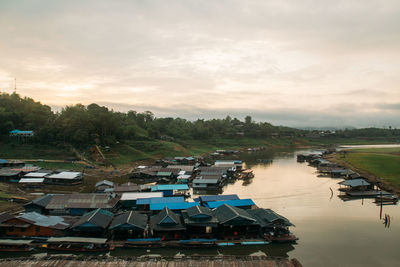 High angle view of buildings by river against sky