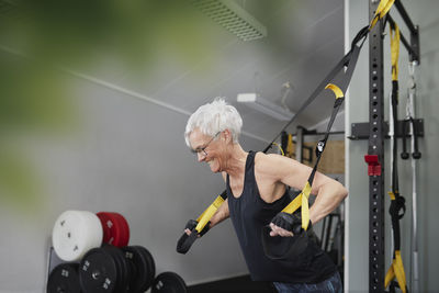 Woman using training equipment in gym