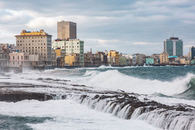 Scenic view of sea by buildings against sky