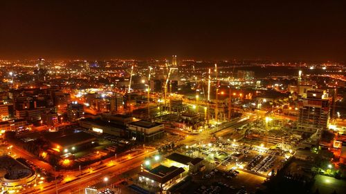 High angle view of illuminated buildings against sky at night