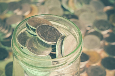 Close-up of coins in jar on table