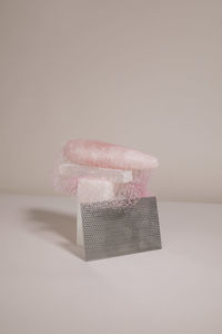 Close-up of pink umbrella on table against white background