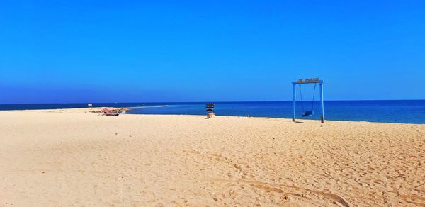 Scenic view of beach against clear blue sky