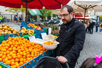 Man holding fruits at market stall