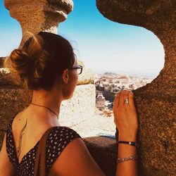 Rear view of woman standing by wall