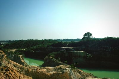 Scenic view of river by mountains against clear sky