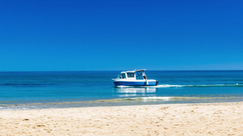 Scenic view of sea against clear blue sky