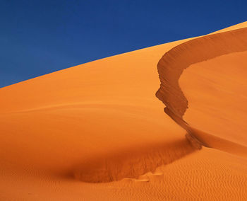 Sand dunes in desert against clear sky