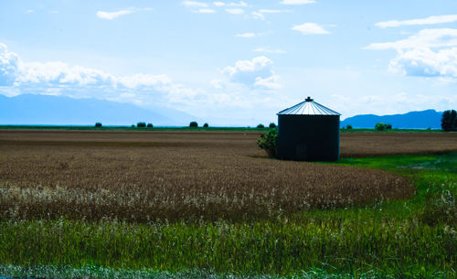 Scenic view of field against cloudy sky