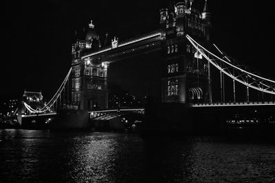 Low angle view of illuminated tower bridge over thames river at night