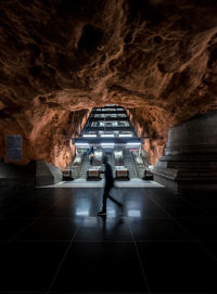 Rear view of man standing in subway tunnel