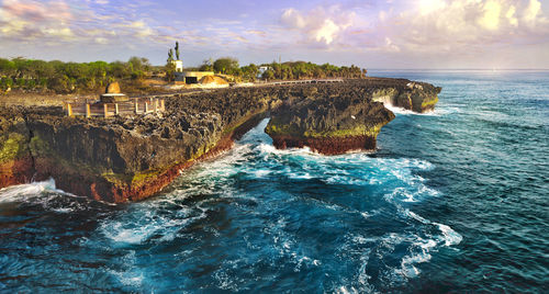 Panoramic shot of rocks in sea against sky