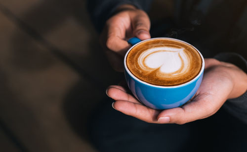 Cropped image of hand holding coffee cup