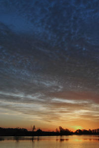 Scenic view of lake against sky at sunset