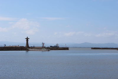 View of statue in sea against cloudy sky