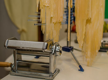 Close-up of pasta with maker on kitchen counter