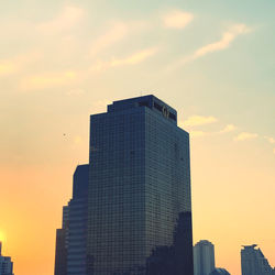 Low angle view of modern buildings against sky during sunset