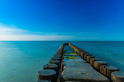 Pier over sea against blue sky