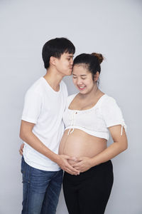 Young couple standing against white background