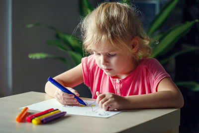 Cute girl drawing on book