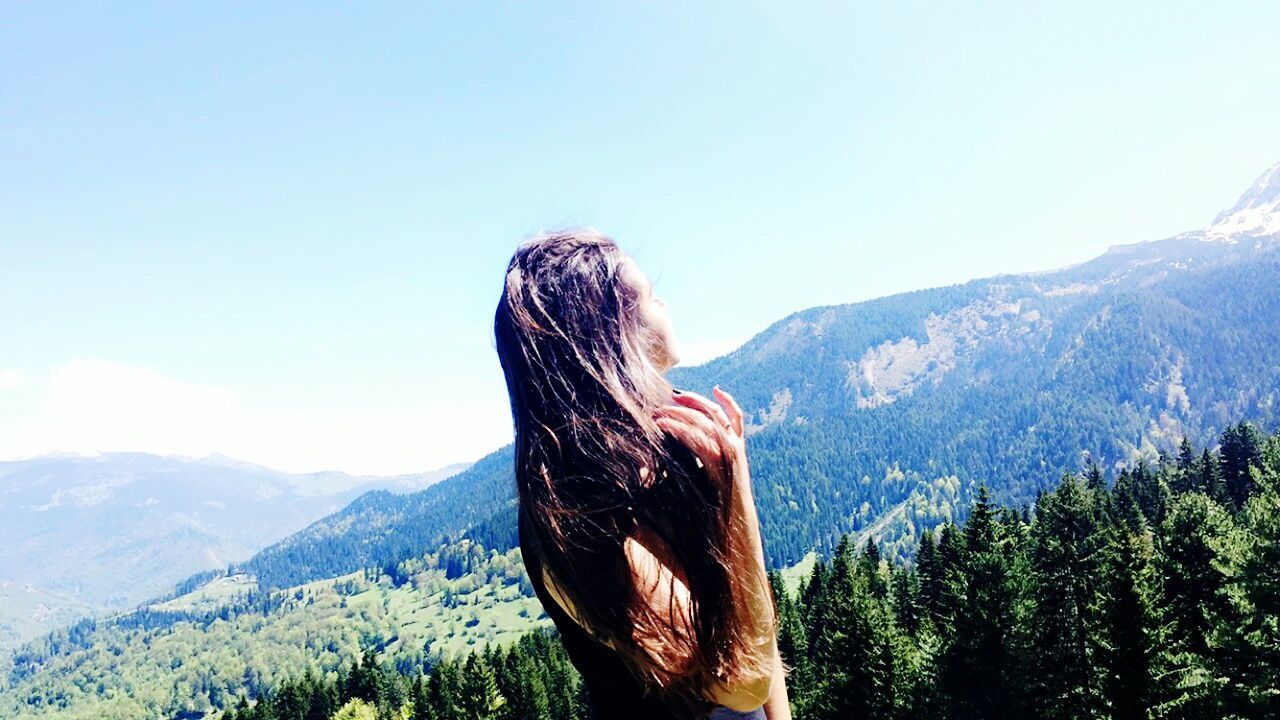 WOMAN STANDING ON MOUNTAIN