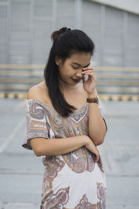 Shy young woman standing in city