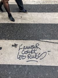 Low section of person with text on road