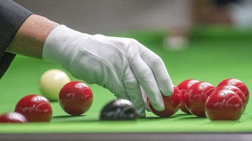 Cropped hand of man adjusting snooker balls on pool table