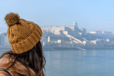 Rear view of woman looking at sea against clear sky