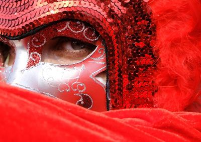 Close-up portrait of man in red venetian mask