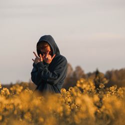 Man standing on field against sky