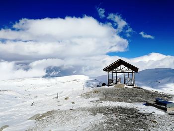 Lifeguard hut on snowcapped mountain against sky